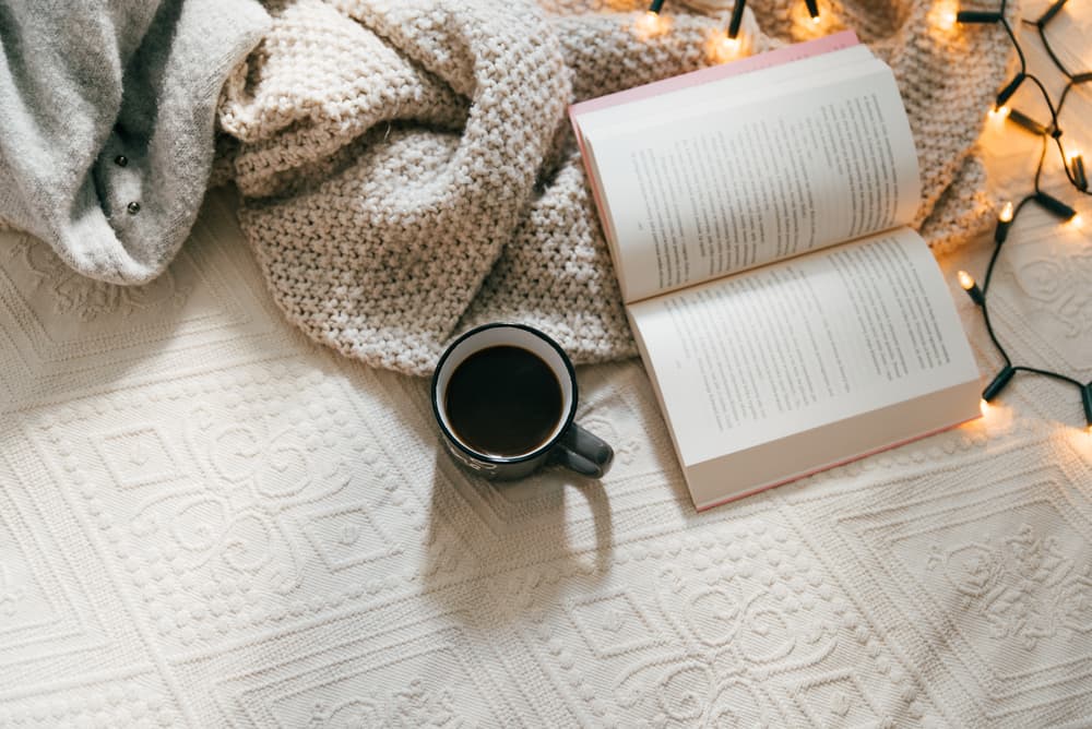 A book, a coffee and a blanket.