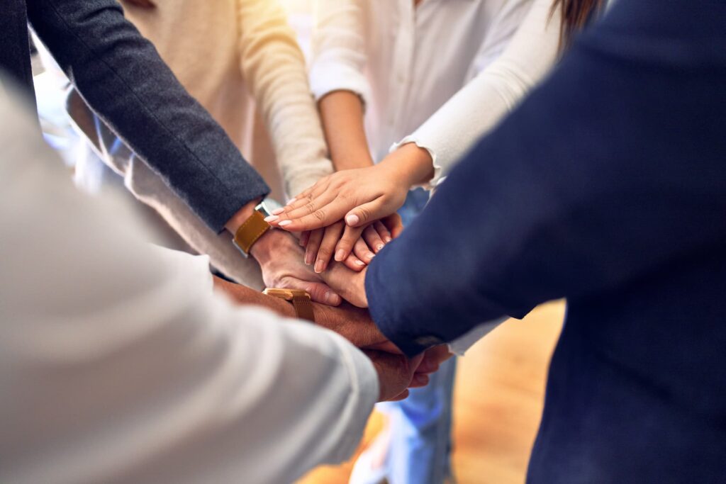 Group Of Business Workers Standing With Hands Together